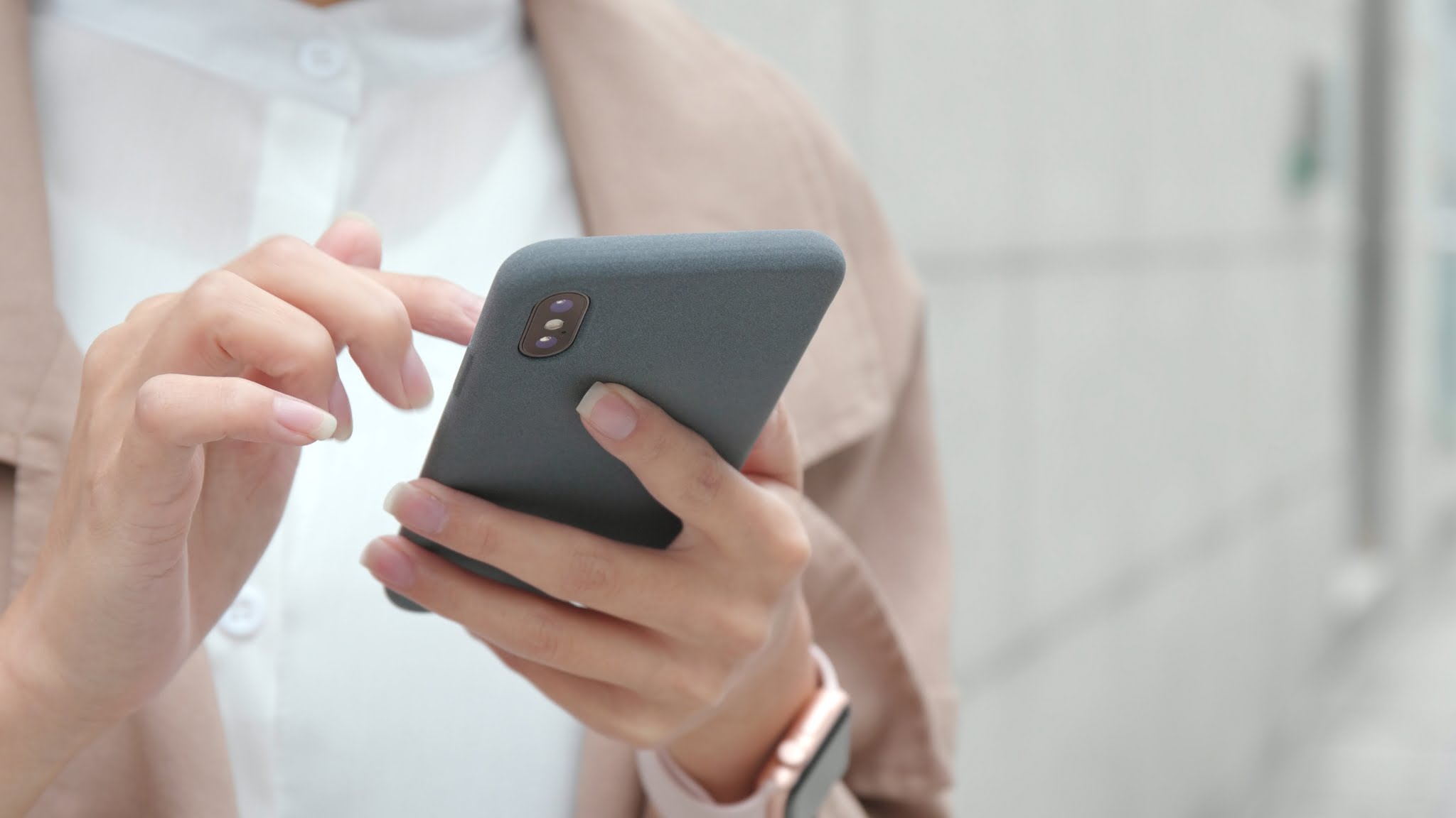 A woman holding a cell phone with her finger. Mobile device user