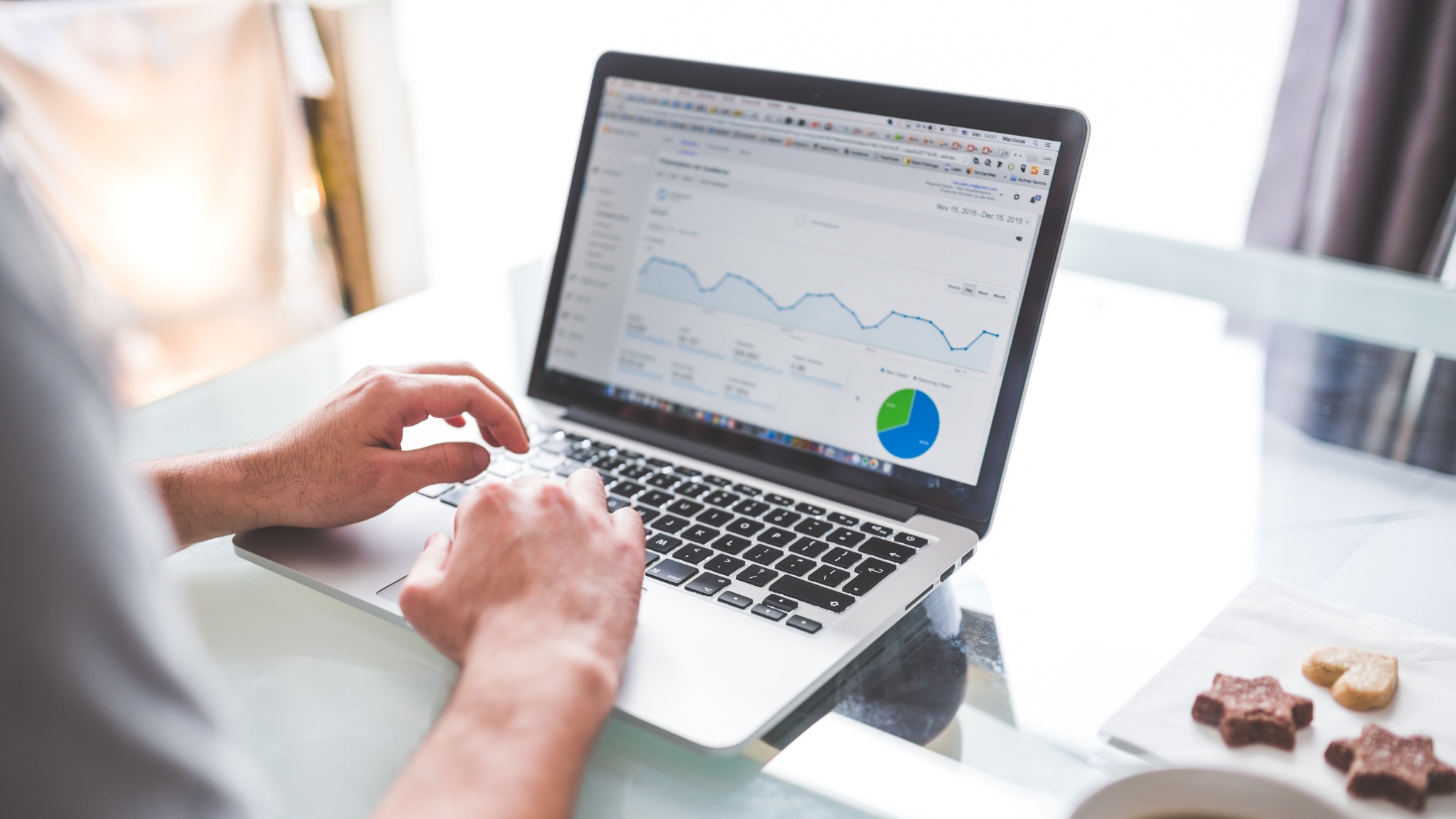 A person analyzing Google Analytics data on a laptop to improve a website, focusing on studying data analytics.