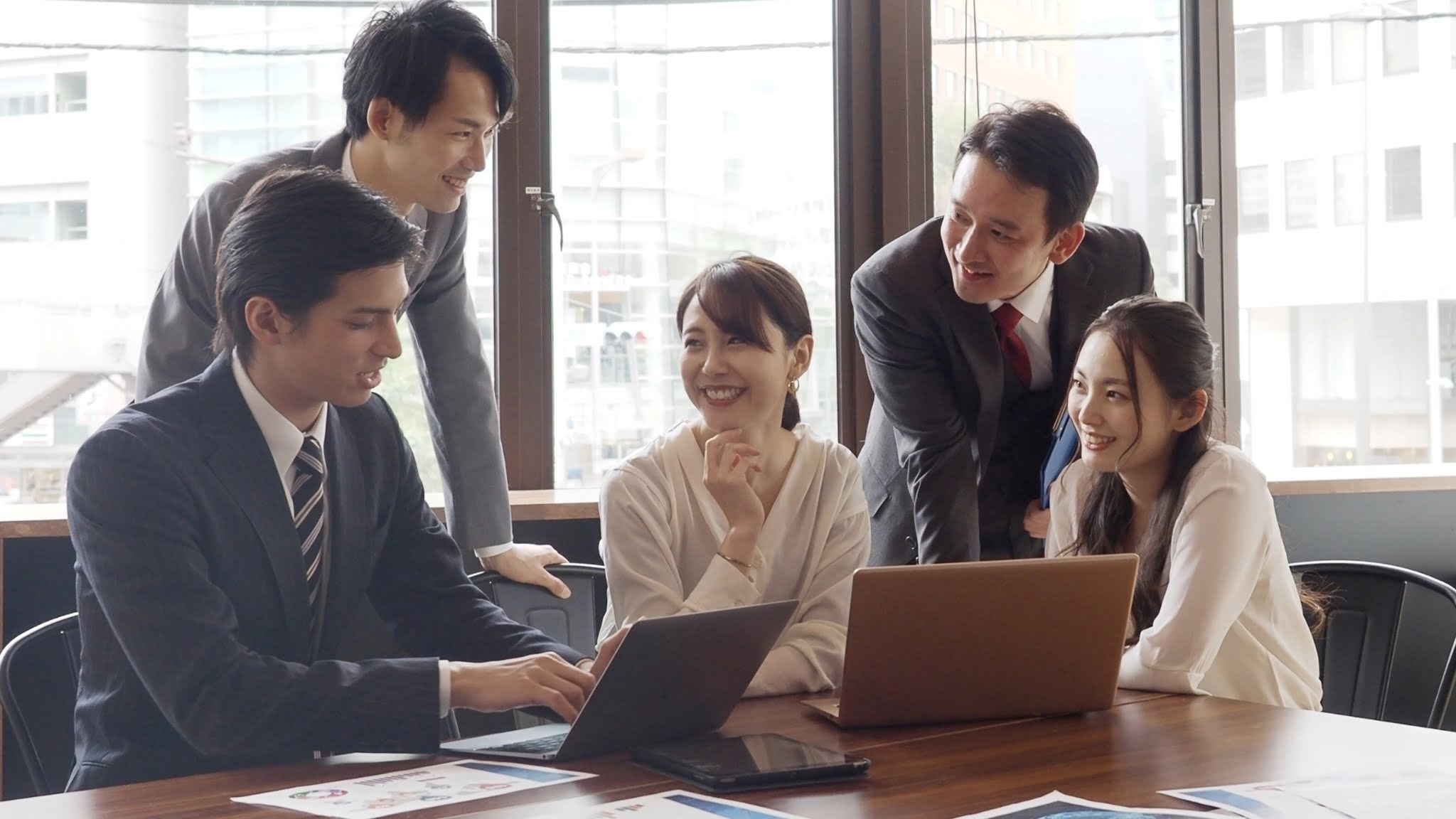 Asian business professionals collaborating in a meeting, engaged in a colleague group discussion