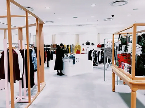 Woman browsing clothes in apparel shop