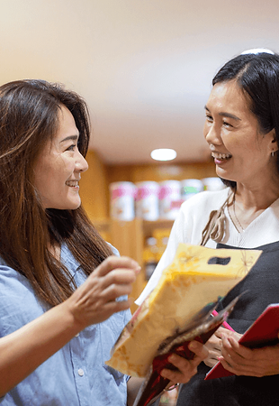 Customer with a big smile on their face, holding a product they just purchased