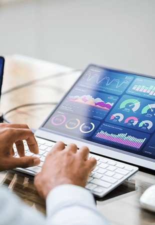 A person analyzing data on a computer screen, using charts and graphs to draw insights