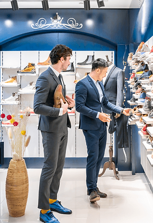 Person browsing through clothing racks in a store.