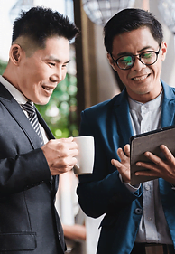 Two businessmen in suits and glasses examining a tablet