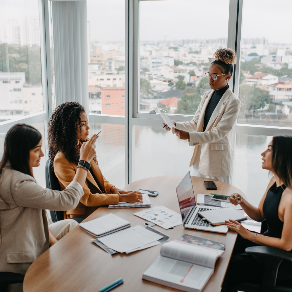 A group of businesswomen discussing leadership and strategic planning in an office meeting.